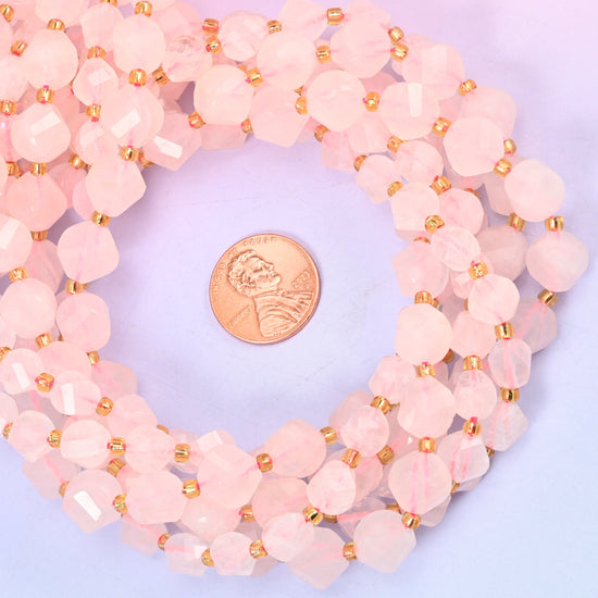 Rose Quartz faceted spiral twist bead strands coiled around a US penny for size reference