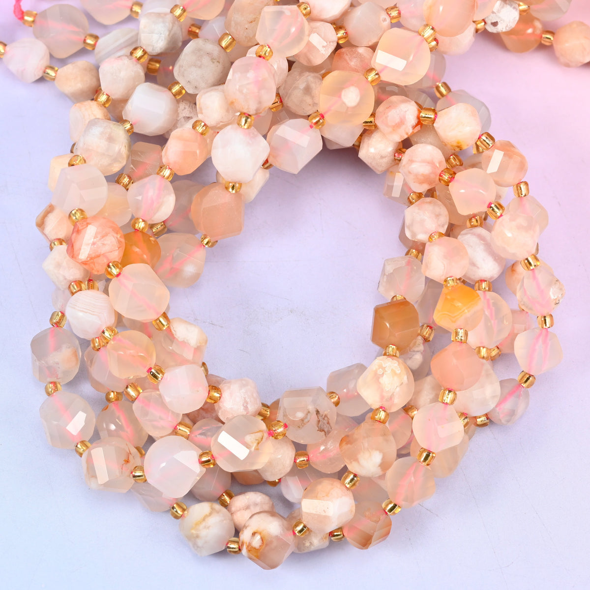 Sakura Flower Agate faceted spiral twist beads, close view of the coiled strands showing cream and soft peach with apricot flecks