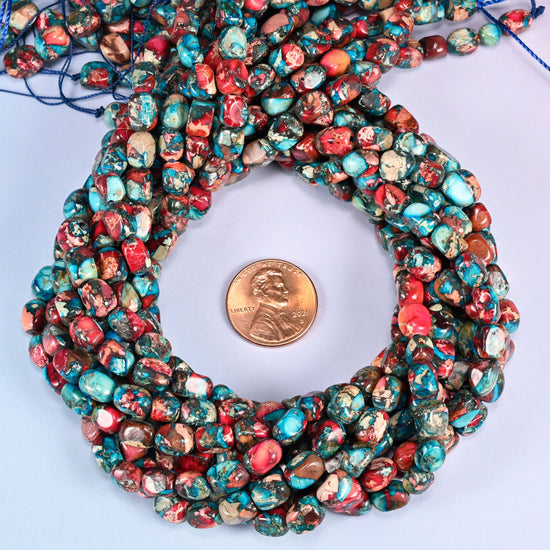 Dyed Sea Sediment Jasper nugget bead strands coiled around a US penny for size reference