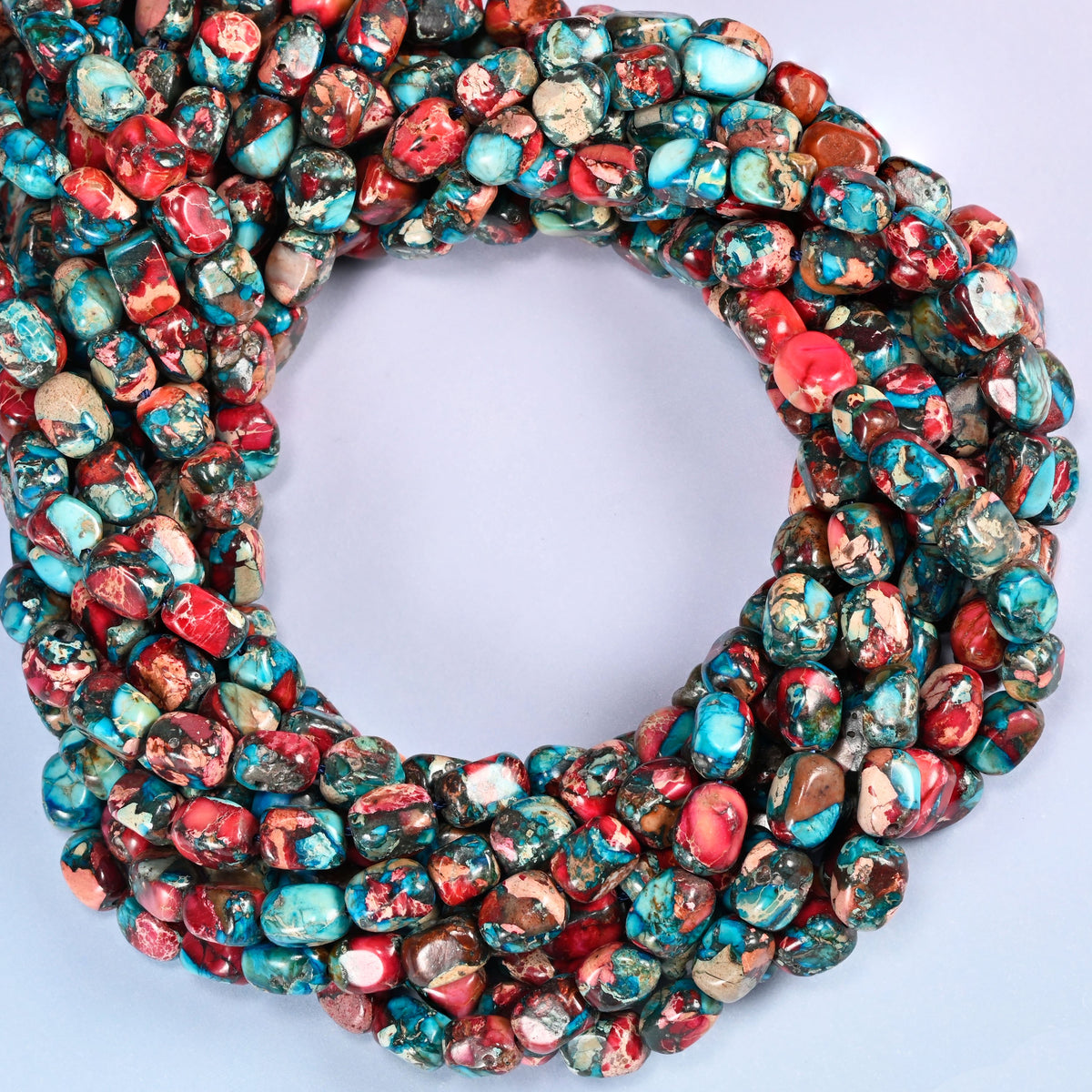 Dyed Sea Sediment Jasper nugget beads, close view of the coiled strands mixing red, turquoise and brown