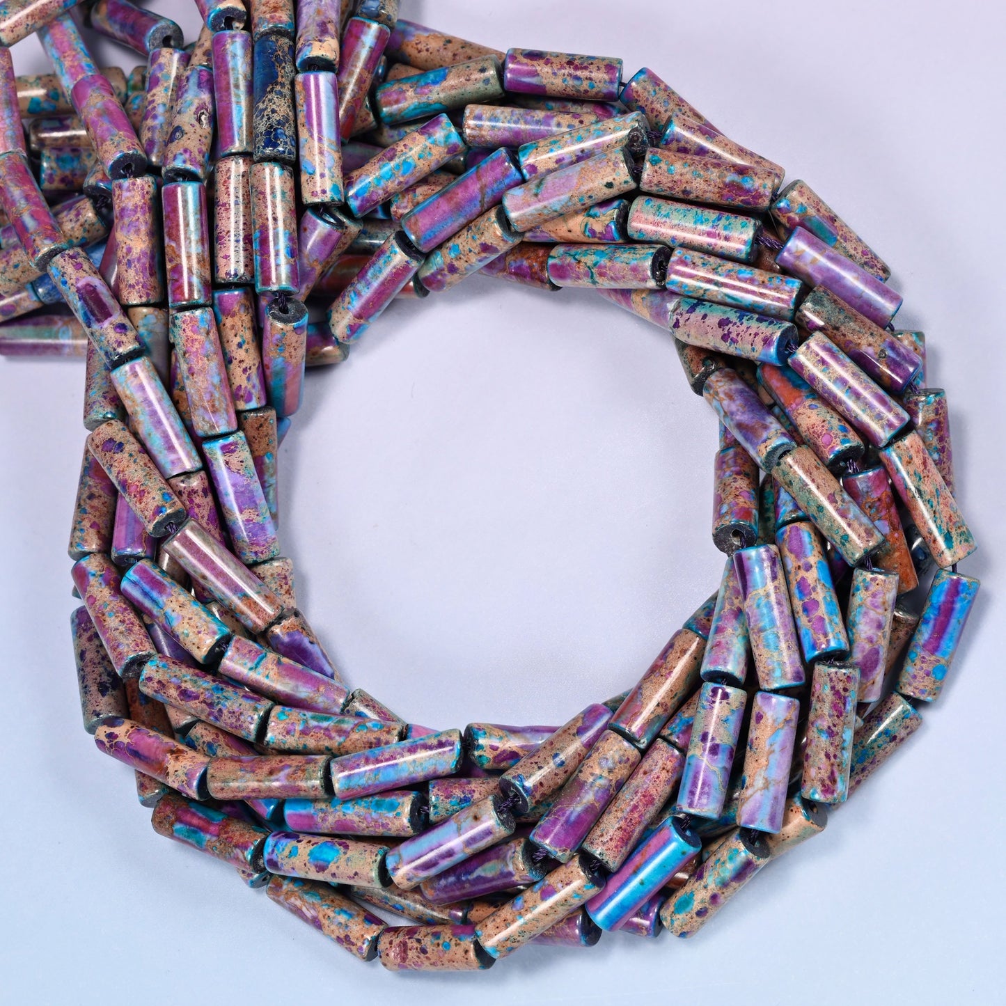 Sea Sediment Jasper tube beads, close view of the coiled strands mixing purple, magenta and turquoise