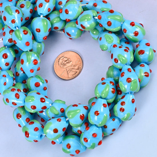 Sky Blue Red Dots Strawberry glass bead strands coiled around a US penny for size reference