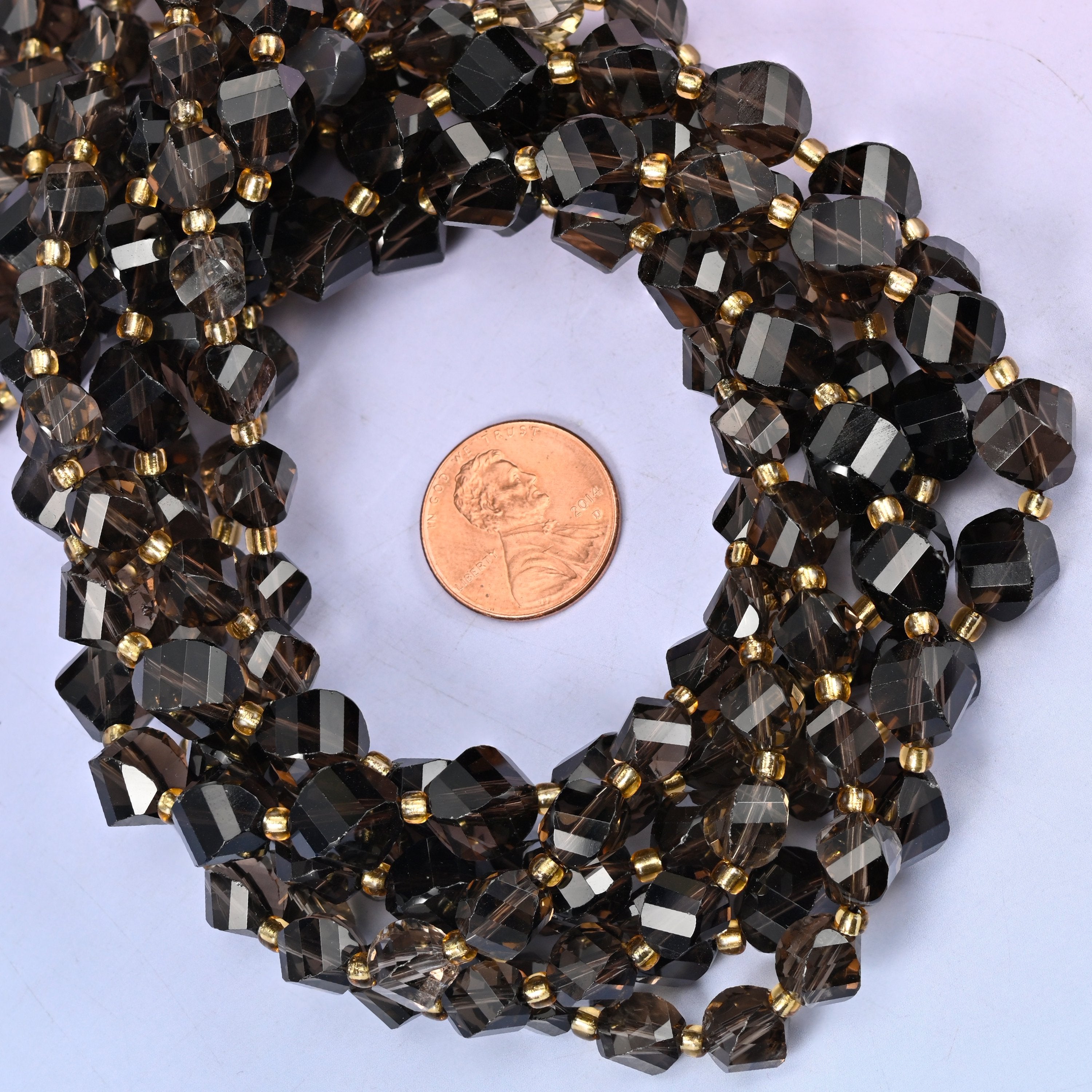 Smoky Quartz faceted spiral twist bead strands coiled around a US penny for size reference