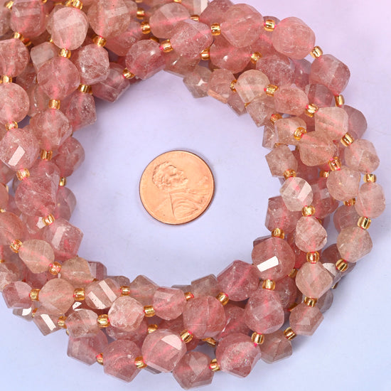 Strawberry Quartz faceted spiral twist bead strands coiled around a US penny for size reference