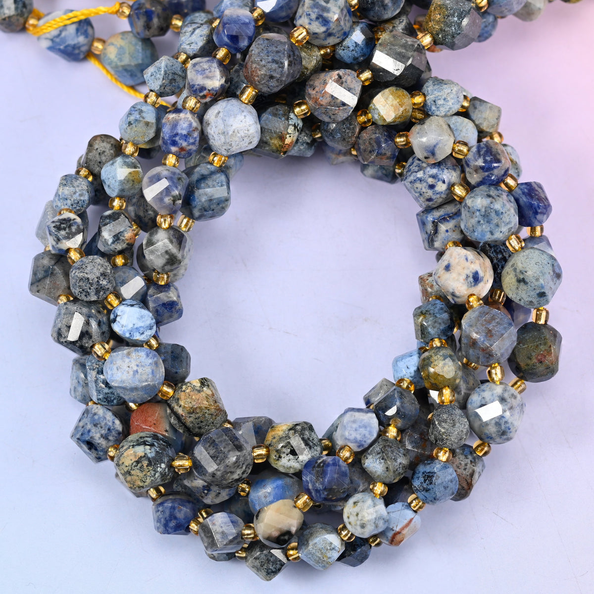 Sunset Dumortierite faceted spiral twist beads, close view of the coiled strands showing denim blue mottled with grey, rust and cream