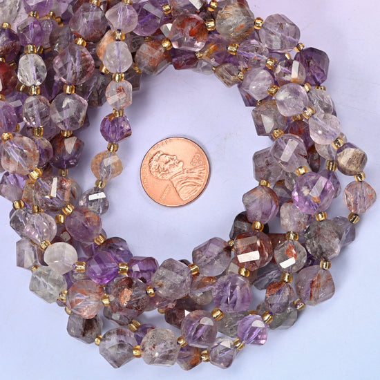 Super 7 Phantom faceted spiral twist bead strands coiled around a US penny for size reference