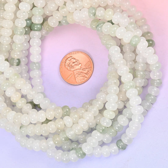 Tianshan Jade smooth rondelle bead strands coiled around a US penny for size reference