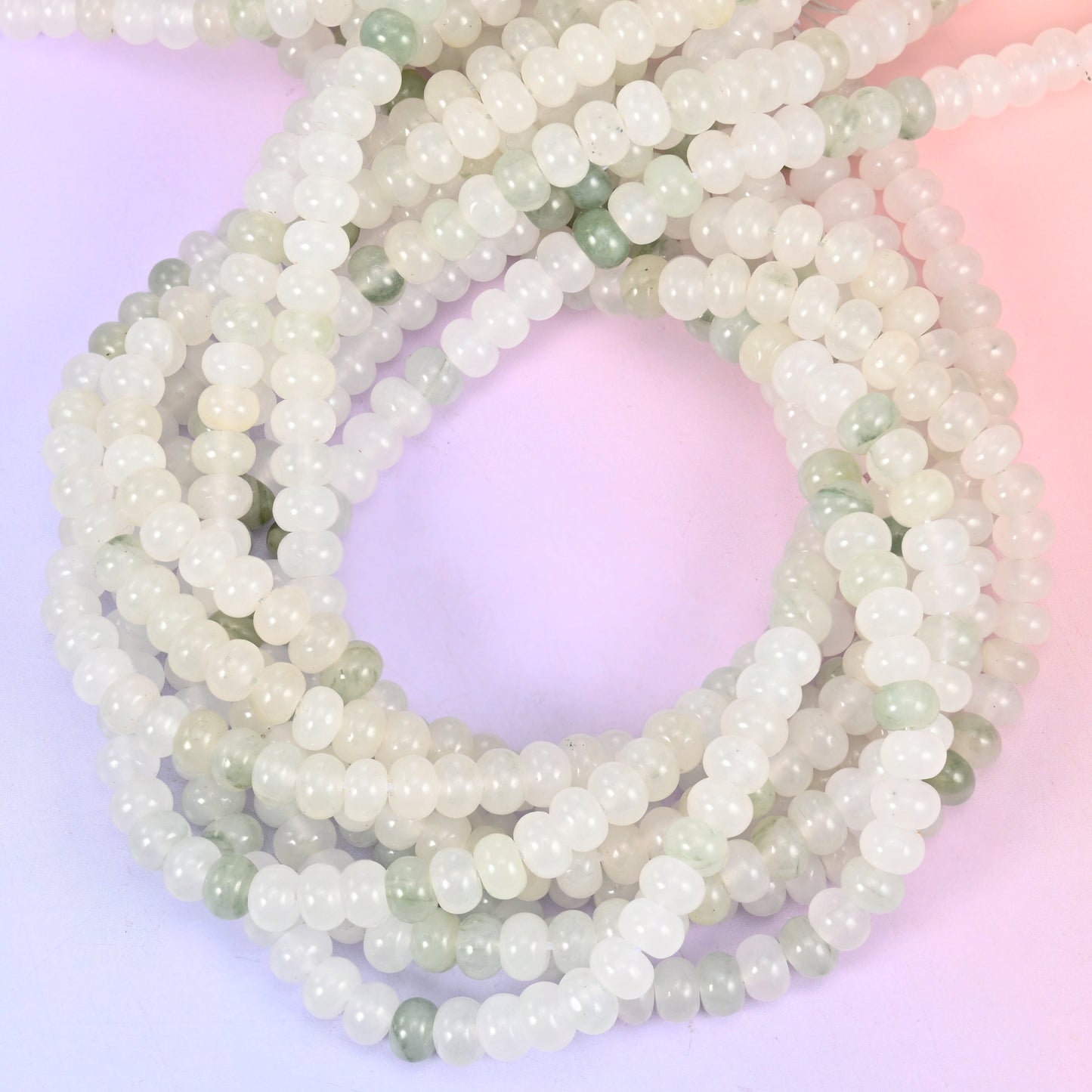 Tianshan Jade smooth rondelle beads, close view of the coiled strands showing milky white with soft green patches