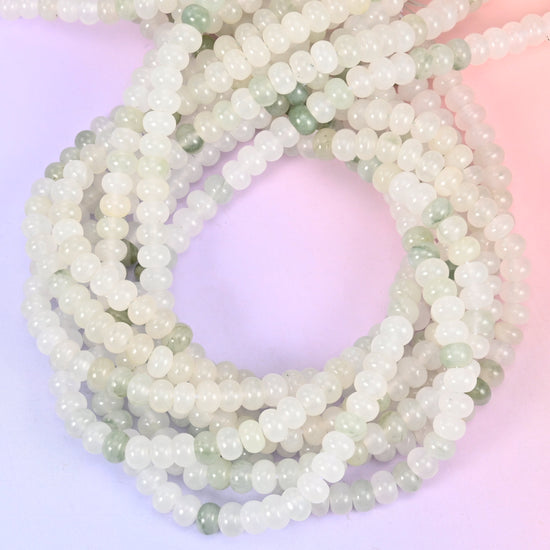 Tianshan Jade smooth rondelle beads, close view of the coiled strands showing milky white with soft green patches