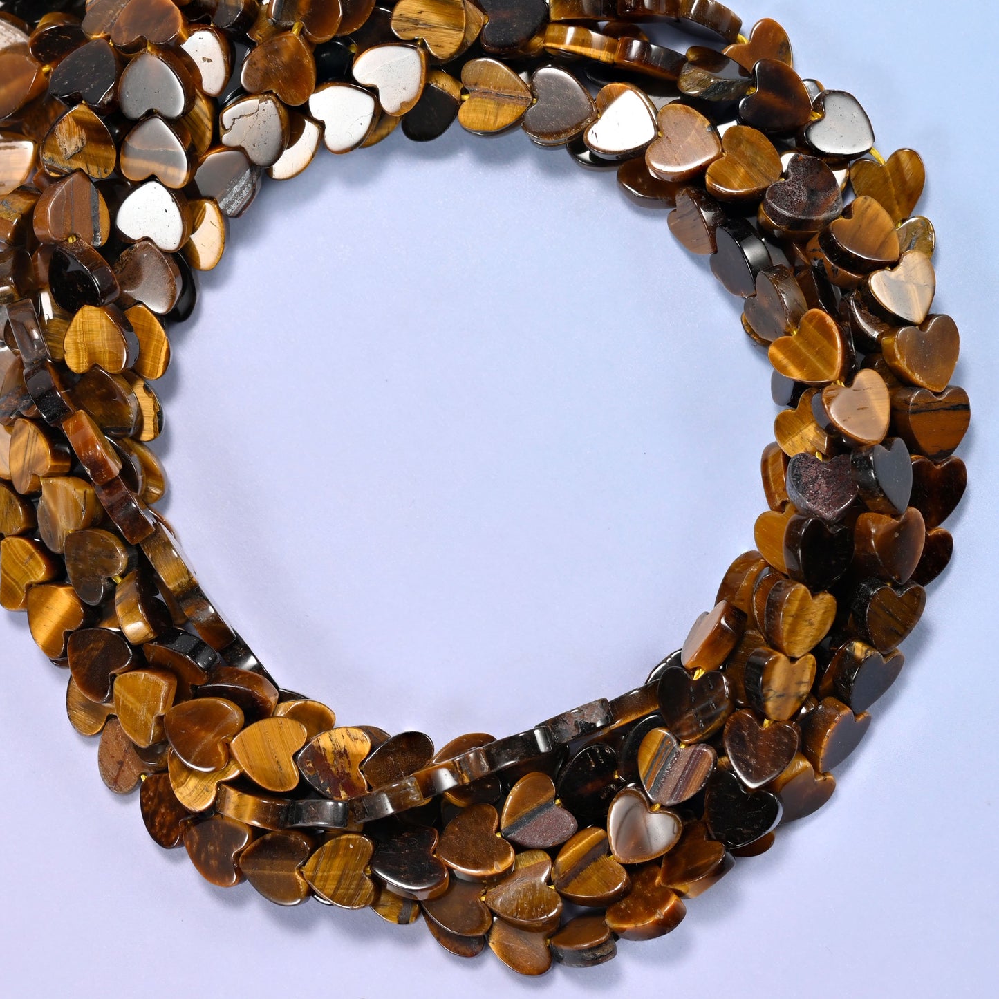 Tiger Eye flat heart beads, close view of the coiled strands in golden brown with dark banding