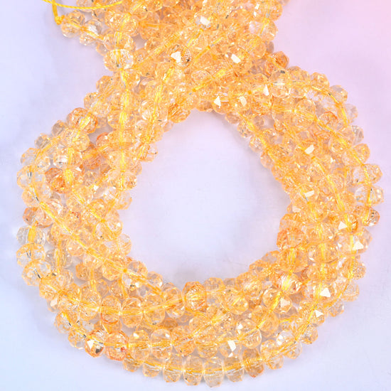 Transparent gold faceted glass rondelle beads, close view of the coiled strands showing clear amber gold