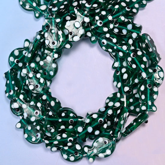 Transparent Jungle Green Fish glass beads, close view of the coiled strands in deep green with white spots