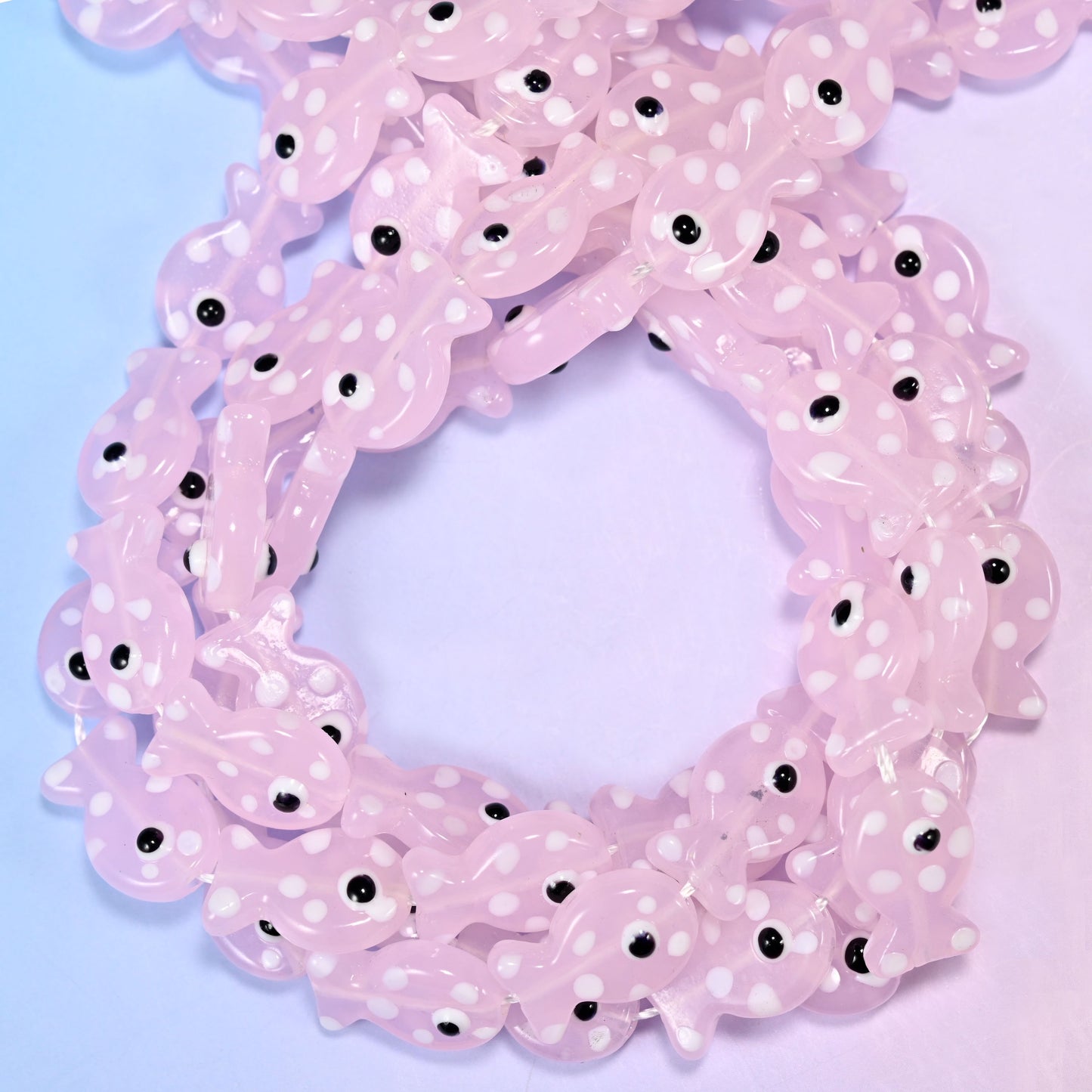 Transparent Pink with White Dot Fish glass beads, close view of the coiled strands in soft pink with white spots
