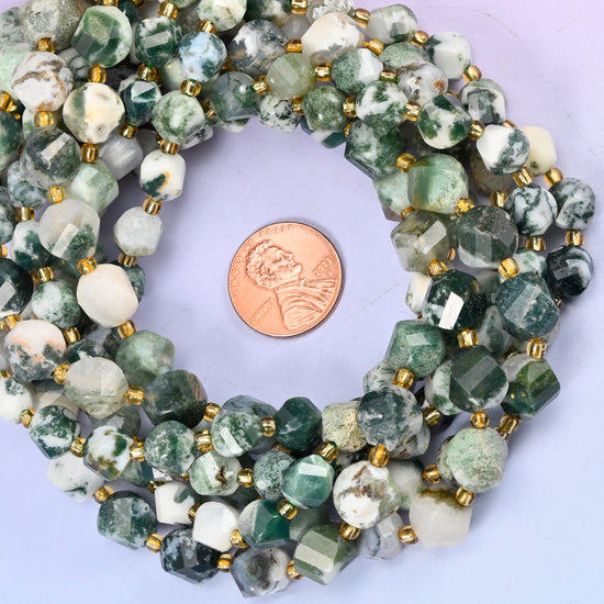 Tree Agate faceted spiral twist bead strands coiled around a US penny for size reference
