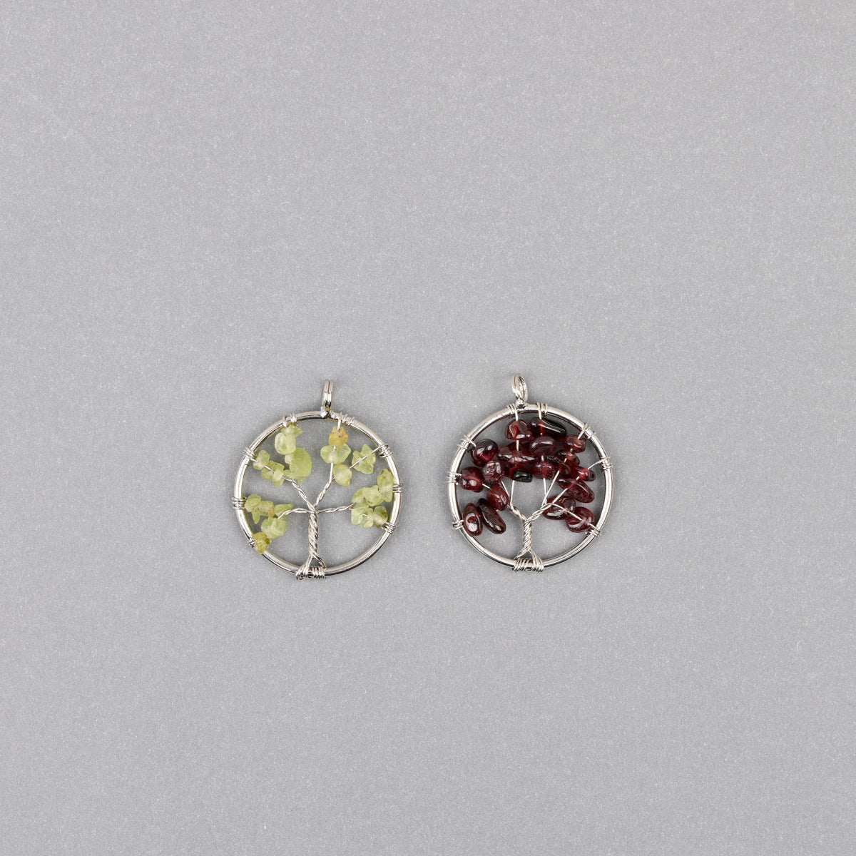 Two 30mm tree of life wire wrapped pendants set with pale green and dark red gemstone chips