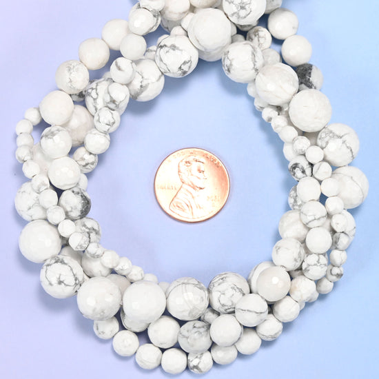 White Howlite faceted round bead strands coiled around a US penny for size reference