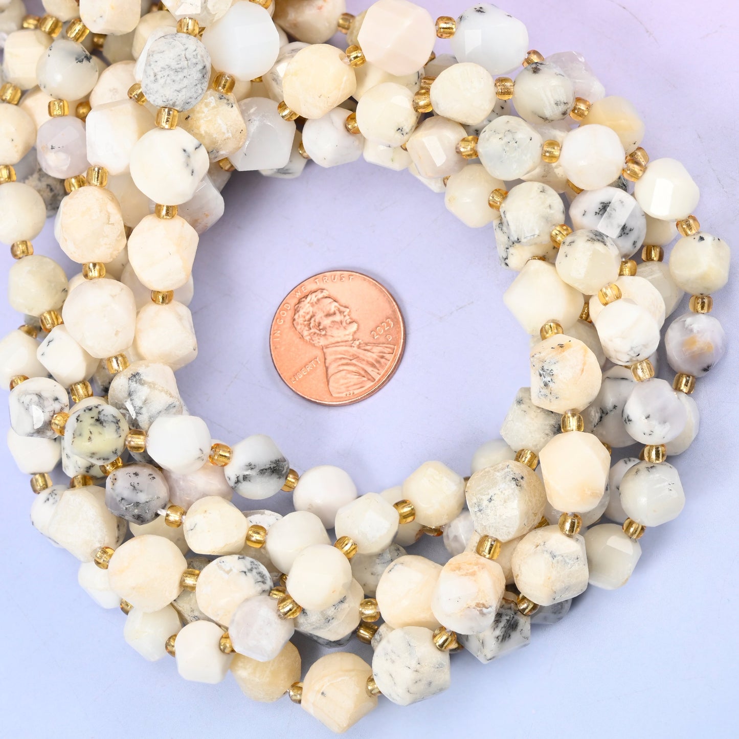 White Opal faceted spiral twist bead strands coiled around a US penny for size reference