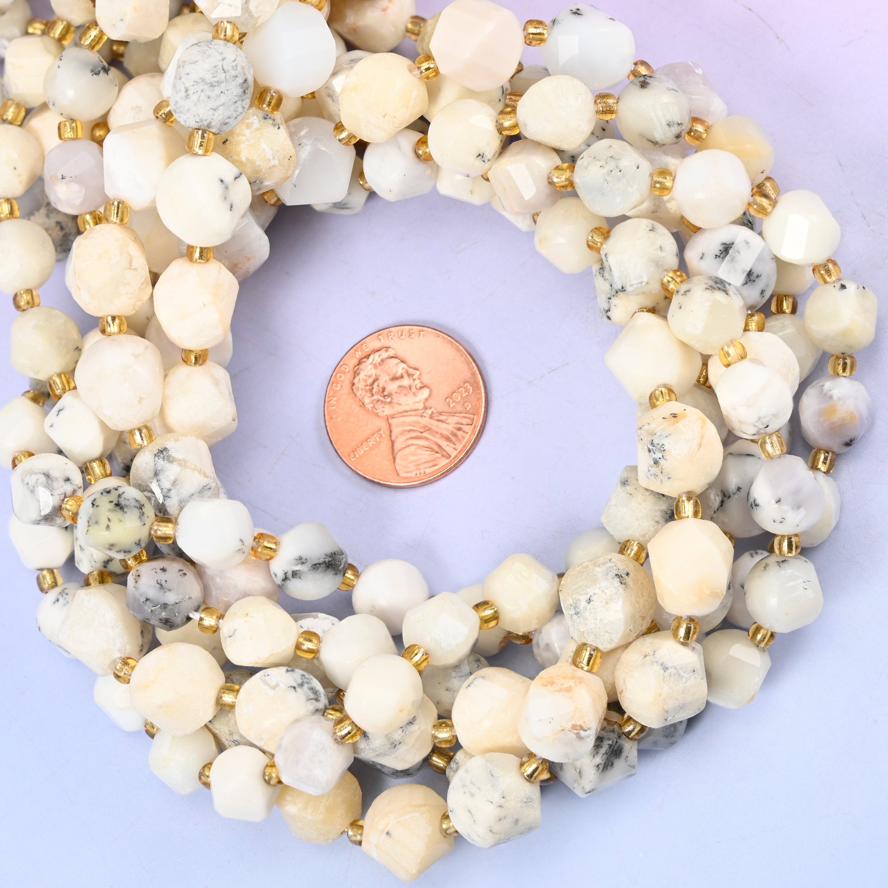 White Opal faceted spiral twist bead strands coiled around a US penny for size reference