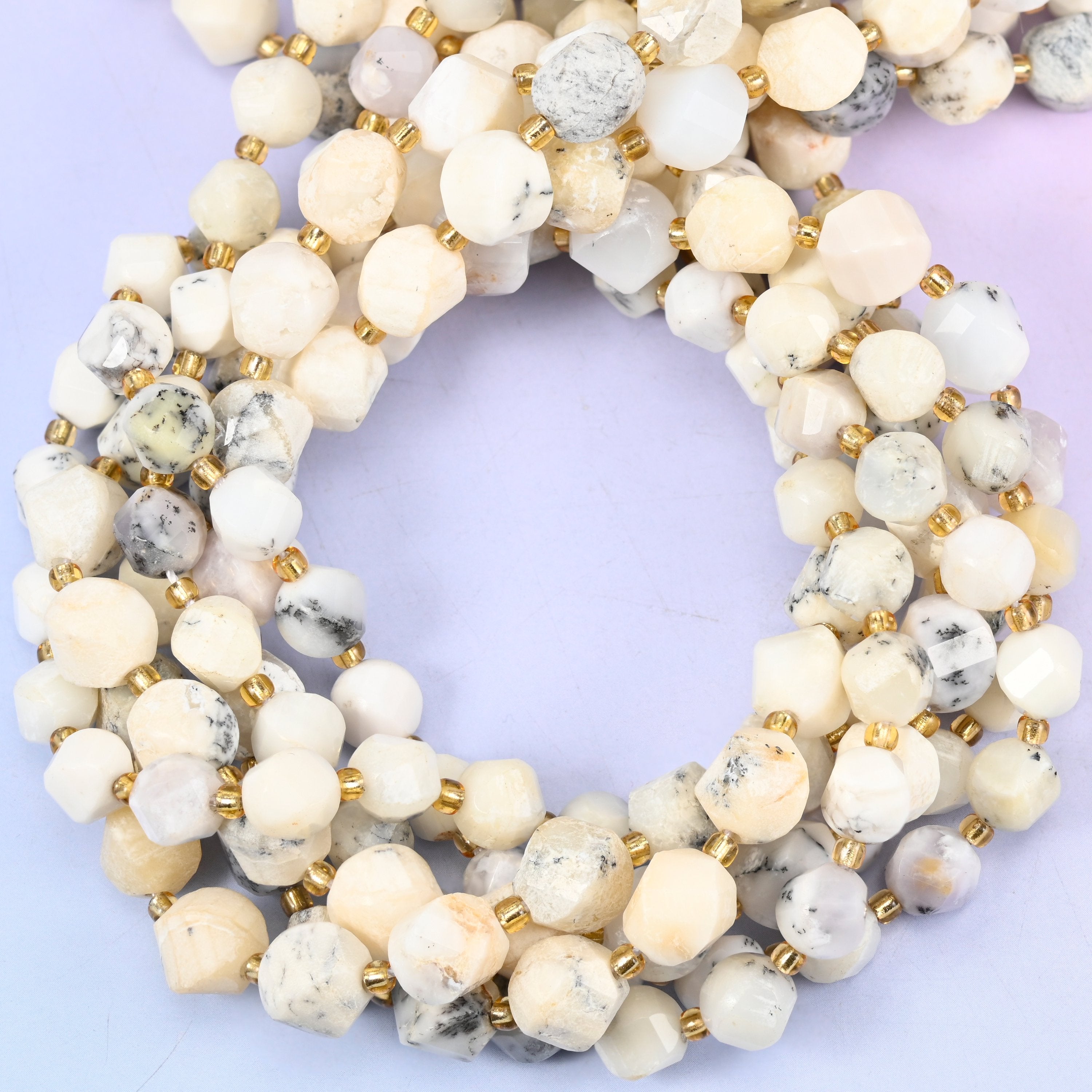 White Opal faceted spiral twist beads, close view of the coiled strands in cream and white with grey speckling