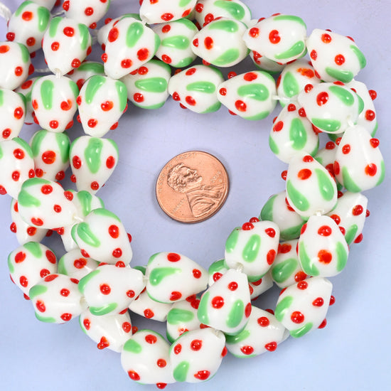 White Red Dots Strawberry glass bead strands coiled around a US penny for size reference
