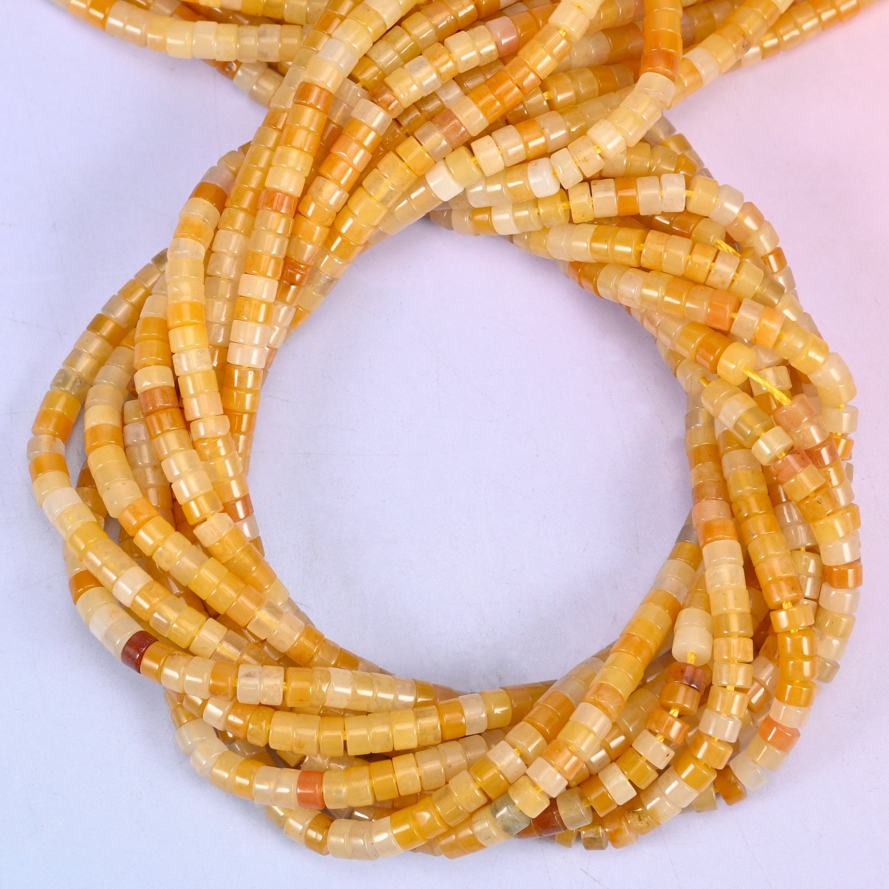 Yellow Jade smooth heishi disc beads, close view of the coiled strands showing golden yellow with cream and amber banding