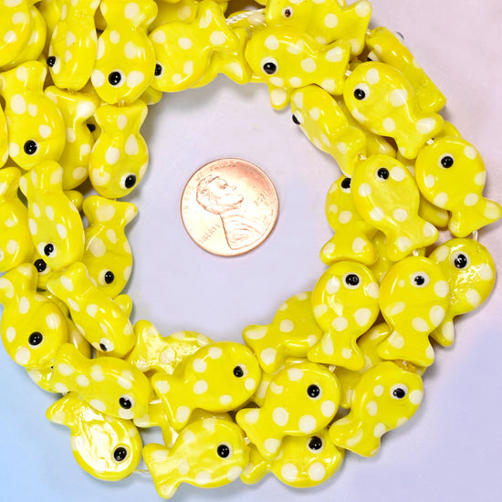 Yellow with White Dot Fish glass bead strands coiled around a US penny for size reference